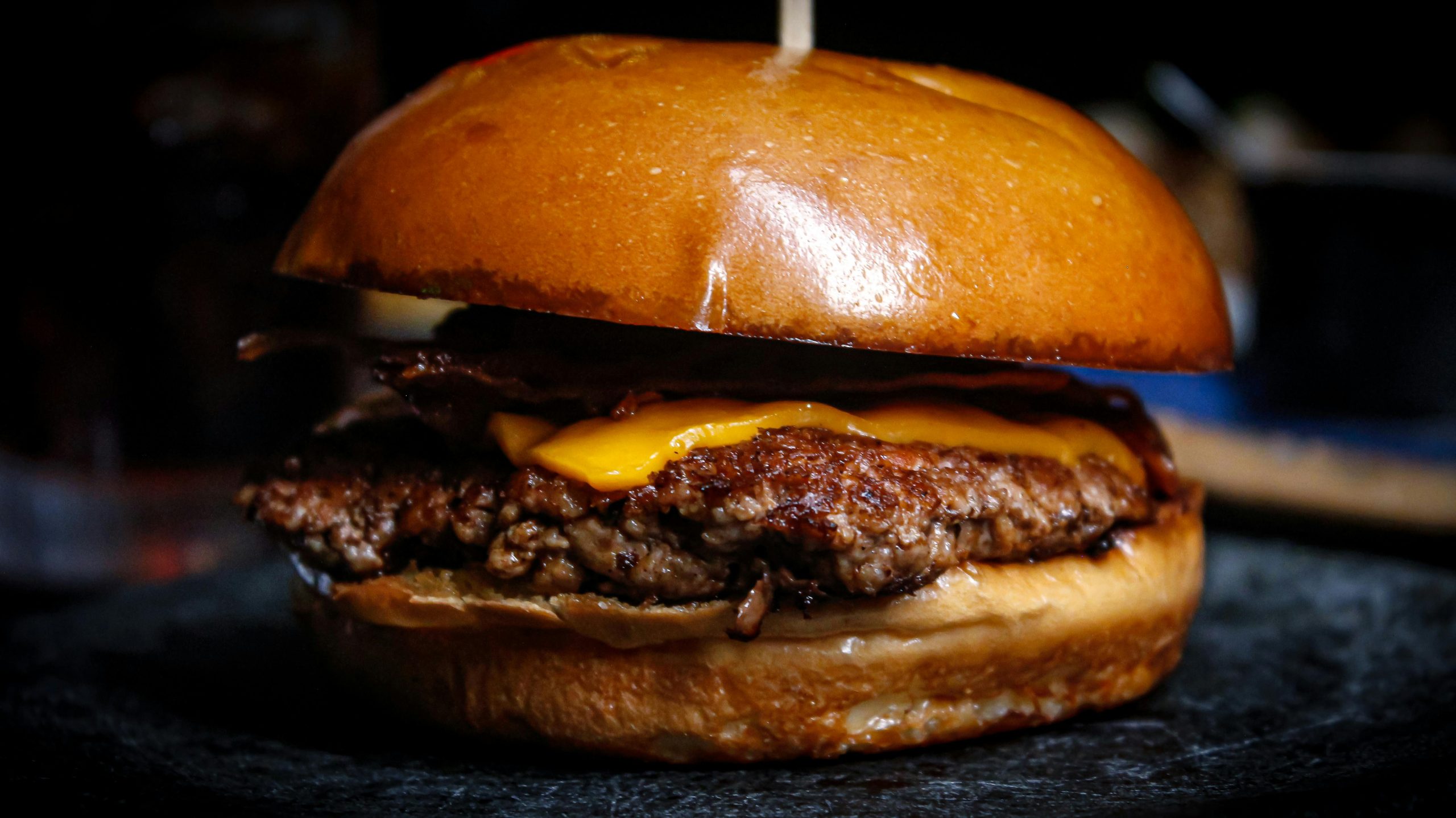 Mouth-watering close-up of a cheeseburger with bacon, ideal for food photography.